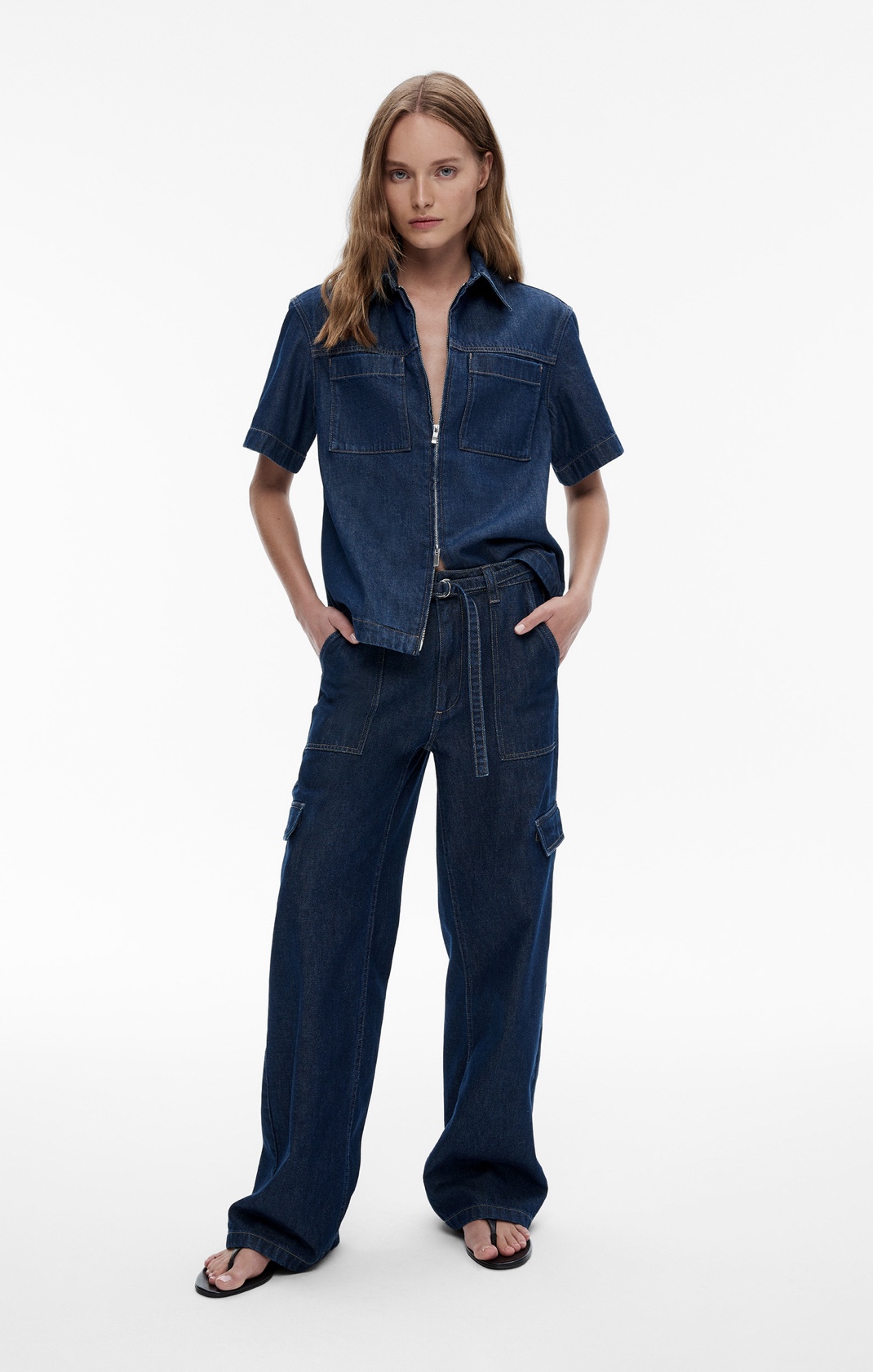 Woman in denim short sleeve shirt, denim cargo jeans and black leather sandals