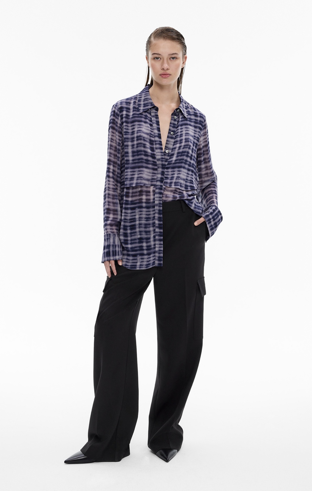 Woman in print shirred long sleeve shirt, black cargo pants and black point heels