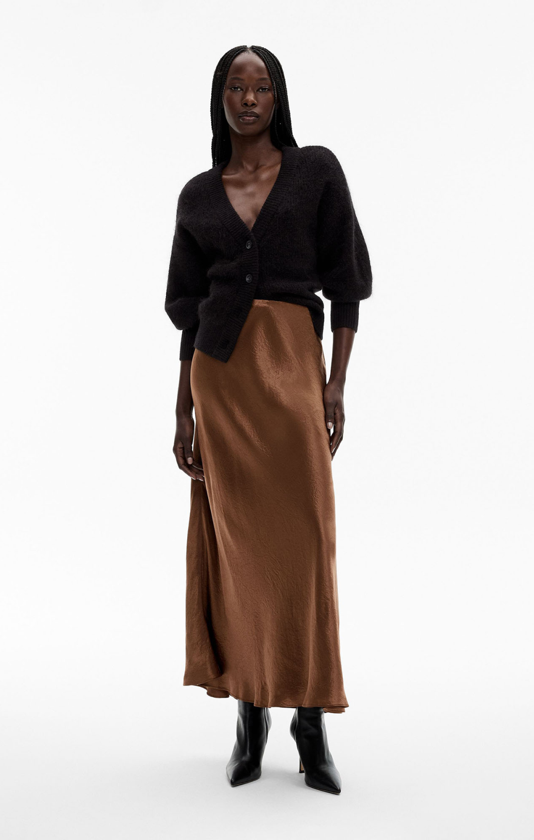 Woman in black knit cardigan and brown midi slip skirt