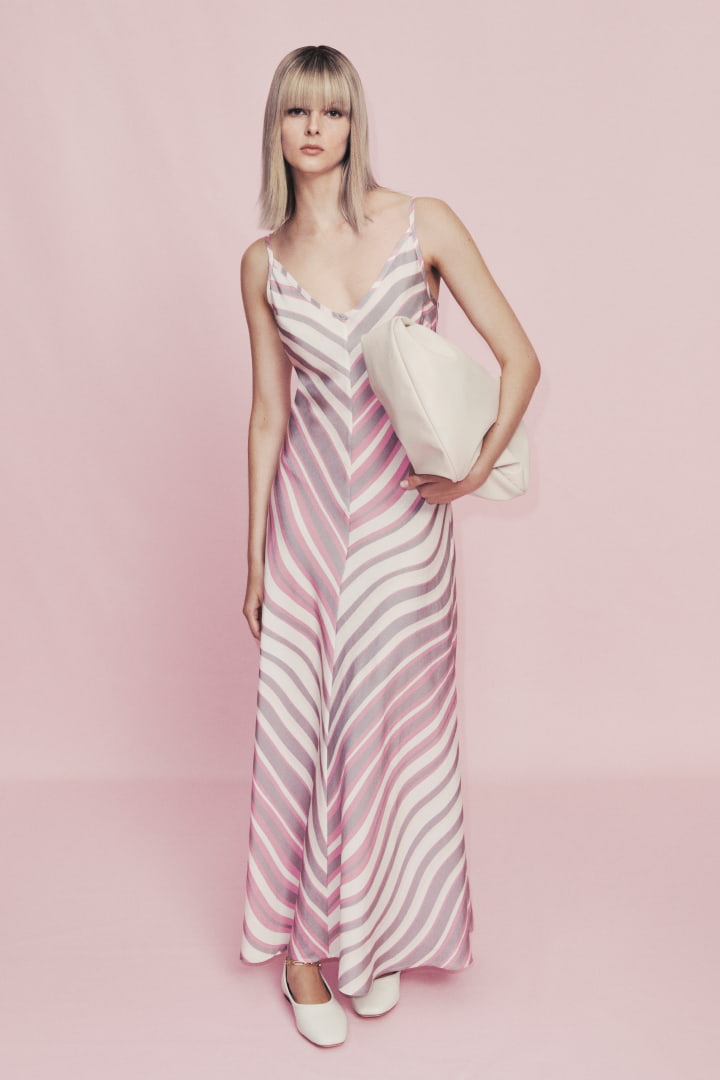 Woman in blush matte maxi slip dress, stone romy medium hobo bag and antique white alyssa ballet