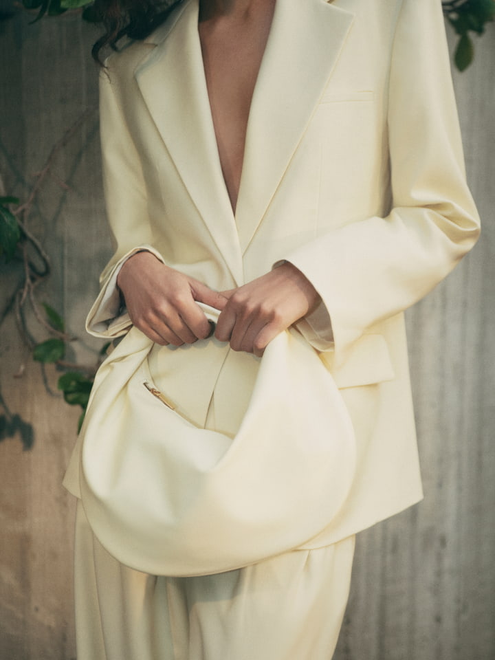 Woman wearing the lemon oversized single breasted blazer, lemon tailored pant and lemon romy hobo bag
