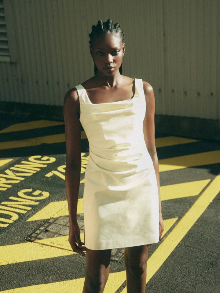 Woman wearing the lemon ruched mini dress