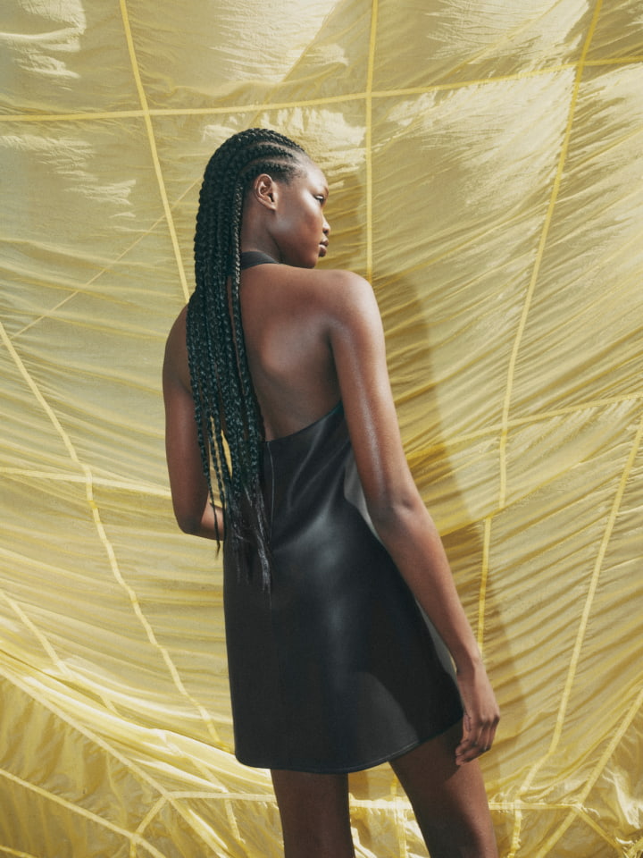 Woman wearing black PU halter dress