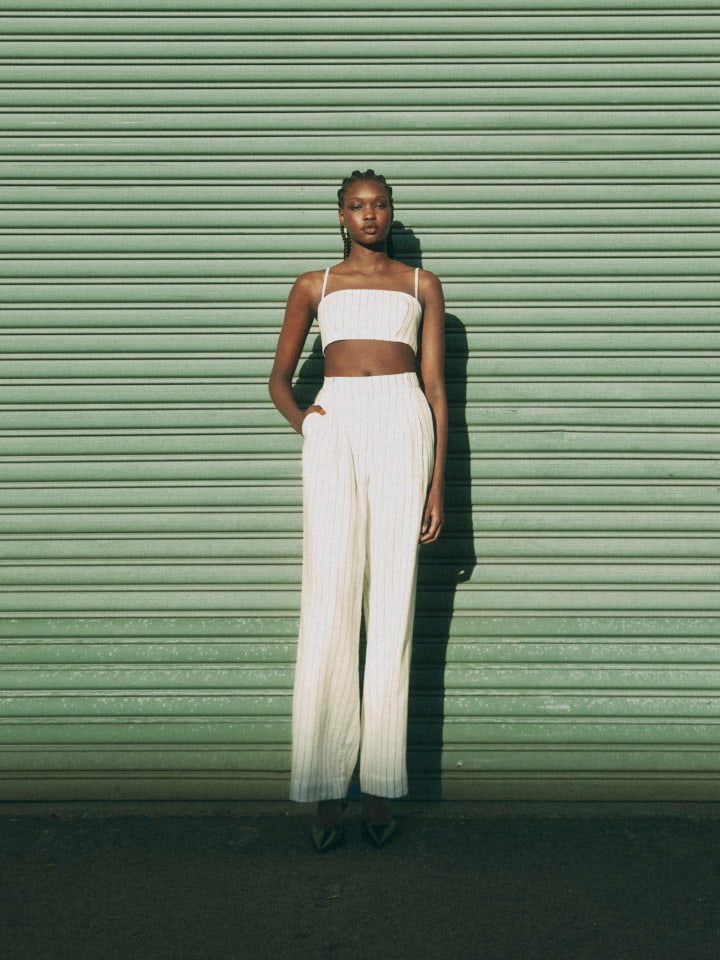 Woman wearing the blanc stripe crop bodice, blanc stripe linen pant and black scarlett mules