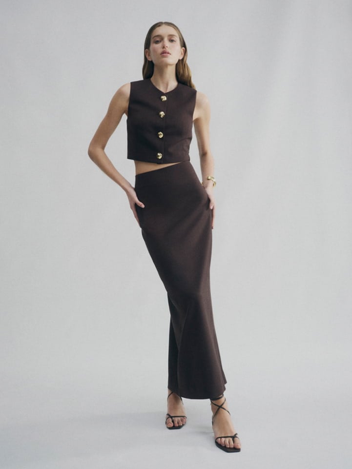 Woman in brown button detail vest, brown classic slimline skirt and brown blair tie up heel