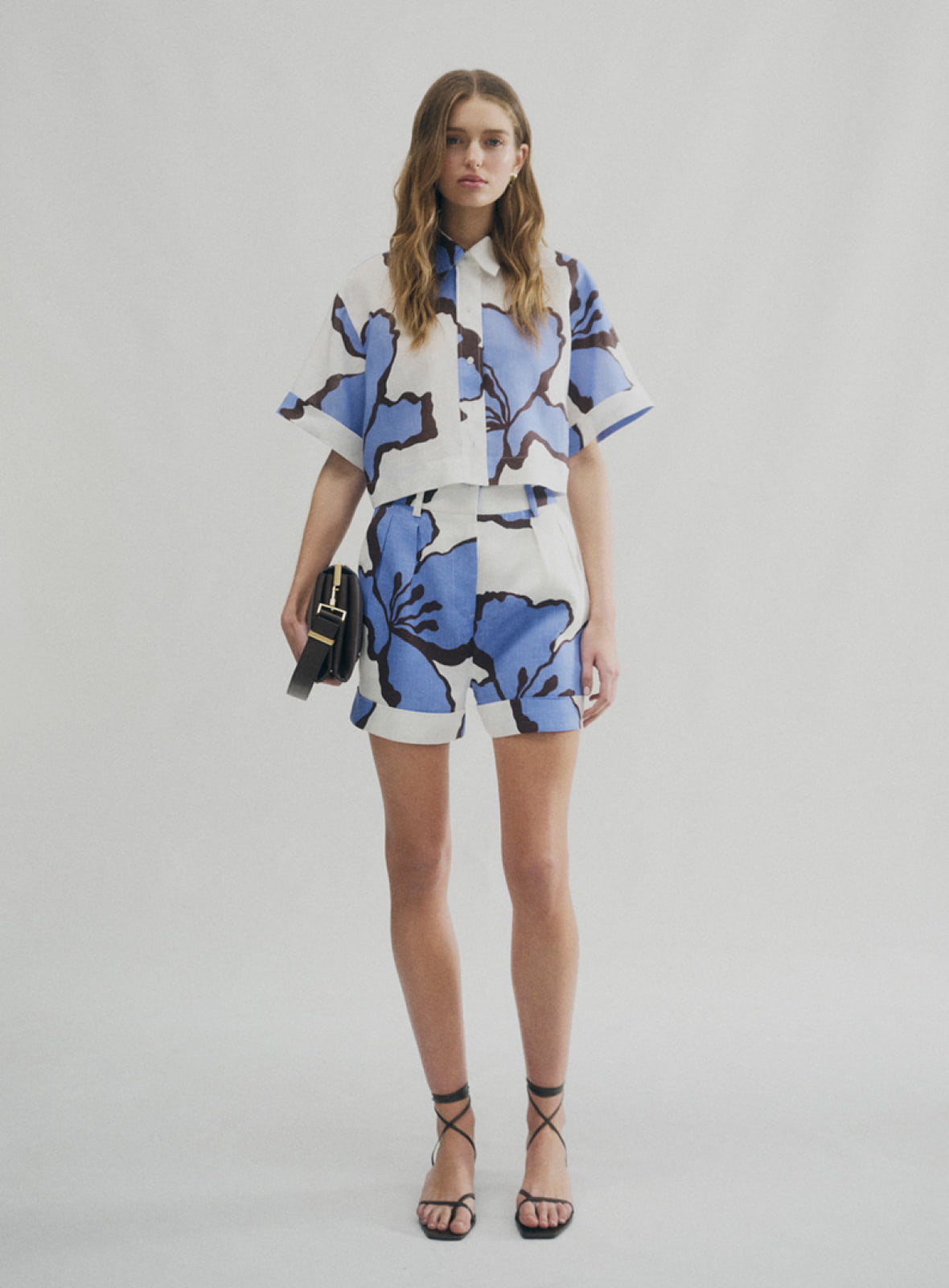 Woman in print linen crop shirt, print linen pleat short, brown liv mini leather bag and blair tie up heel